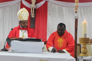 Paroko mpya wa Parokia ya Mtakatifu Karoli Lwanga - Yombo Dovya Jimbo Kuu la Dar es Salaam, Padri Paskal Mapendo, akisaini kiapo cha kukabidhiwa Parokia mbele ya Askofu Msaidizi wa Jimbo Kuu la Dar es Salaam, Mhashamu Vincent Mpwaji wakati wa adhimisho la Misa Takatifu ya Sakramenti ya Kipaimara.