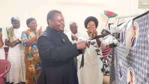 Mkurugenzi wa Utume wa Walei Jimbo Kuu la Dar es Salaam, Padri Vitalis Kasembo, akizindua kitenge cha Wajane na Wagane katika Ofisi za Halmashauri ya Walei zilizopo katika Kanisa Kuu la Mtakatifu Yosefu, jimboni humo. Kulia ni Mwenyekiti wa Chama hicho cha Kitume, Sweetbetha Mzungu. (Picha na Mathayo Kijazi)