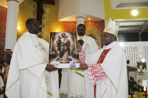 Askofu Msaidizi wa Jimbo Kuu la Dar es Salaam, Mhashamu Vincent Mpwaji (kulia) akimkabidhi picha ya Mt. Josefu Paroko wa Parokia ya Mt. Gaspar del Bufalo, Mbezi Beach, Padri Thaddaeus Memba wakati wa uzinduzi wa Jubilei ya Miaka 75 ya Jimbo Kuu la Dar es Salaam ngazi ya Dekania kwa Dekania ya Mt. Thomas More. Katikati ni Dekano wa Dekania hiyo, Padri Romuald Mukandala.
